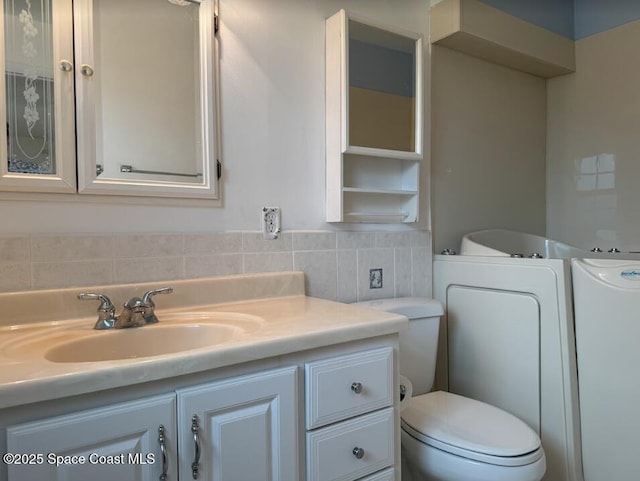 bathroom with vanity, tile walls, and toilet