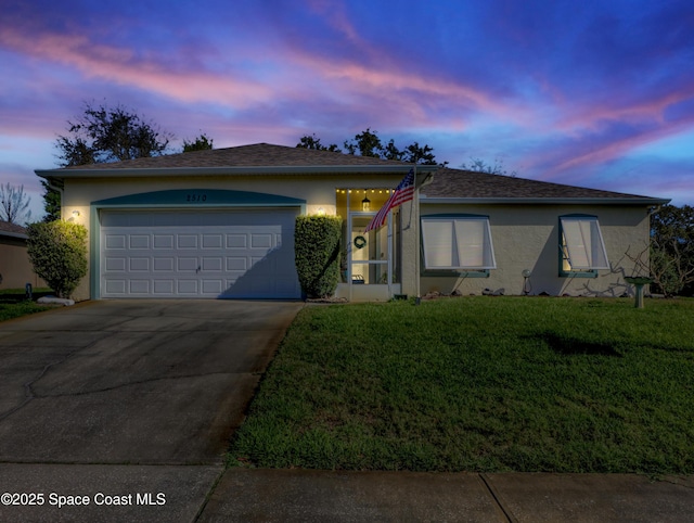 ranch-style home with an attached garage, concrete driveway, roof with shingles, stucco siding, and a front lawn