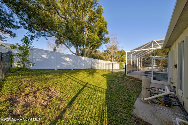 view of yard with glass enclosure and a fenced backyard