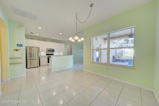 kitchen with white cabinetry, hanging light fixtures, light tile patterned floors, a notable chandelier, and stainless steel appliances