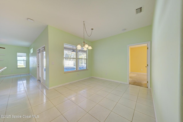 empty room with baseboards, visible vents, a notable chandelier, and light tile patterned flooring