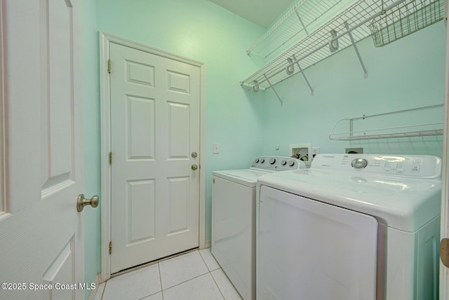 laundry room with washer and dryer, laundry area, and light tile patterned floors