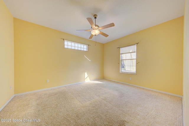 spare room with carpet, ceiling fan, plenty of natural light, and baseboards