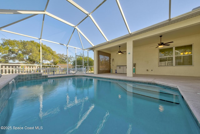 outdoor pool with ceiling fan, a patio, and glass enclosure