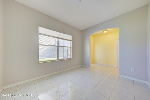 spare room with light tile patterned floors and baseboards