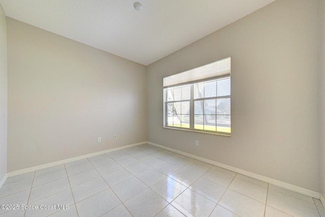 unfurnished room featuring baseboards and light tile patterned floors