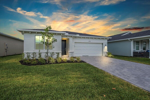 view of front of property featuring a garage and a lawn