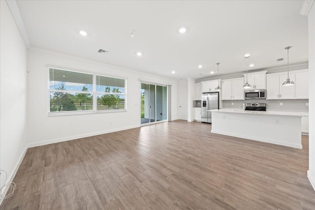 unfurnished living room with light hardwood / wood-style floors and ornamental molding