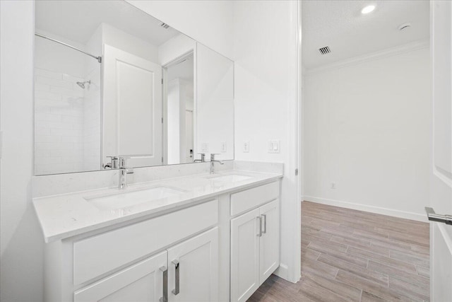 bathroom featuring a shower, vanity, and ornamental molding