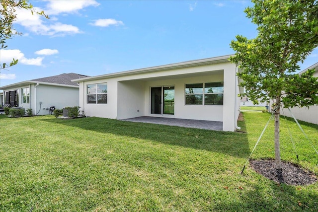 rear view of house featuring a patio area and a yard