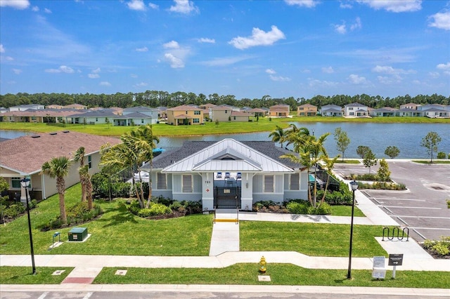 view of front facade with a water view and a front lawn