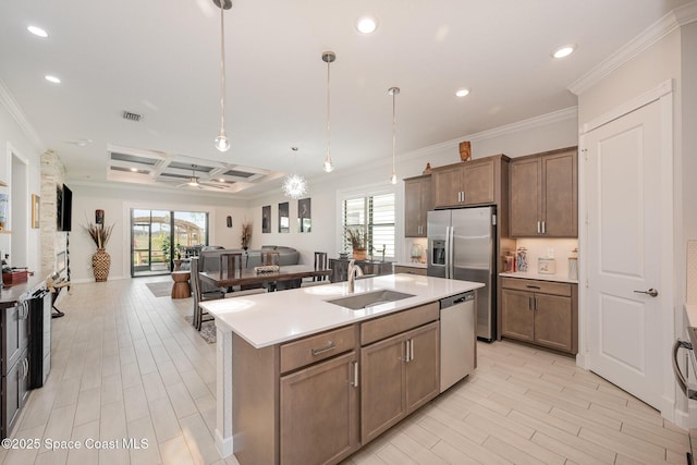 kitchen with sink, decorative light fixtures, appliances with stainless steel finishes, an island with sink, and a wealth of natural light