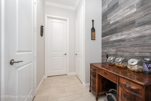 hallway with ornamental molding and wood walls