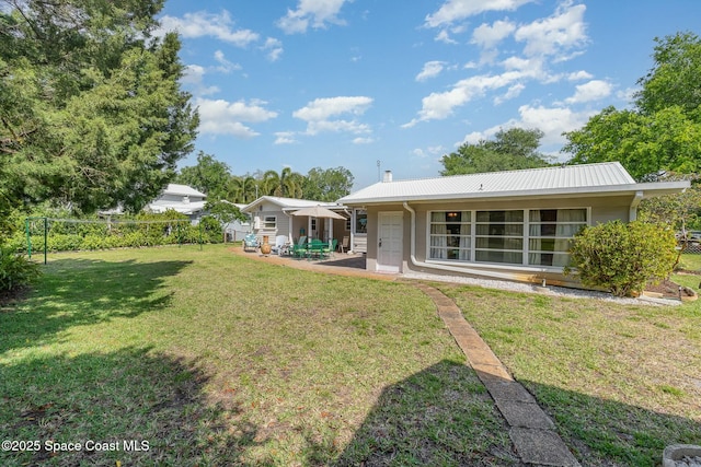 back of property featuring a patio and a yard