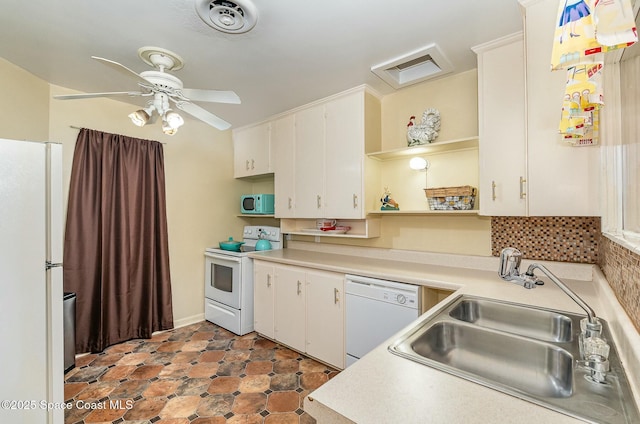 kitchen featuring sink, backsplash, white cabinets, and white appliances