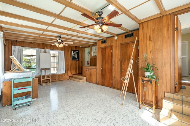 miscellaneous room with ceiling fan and wood walls