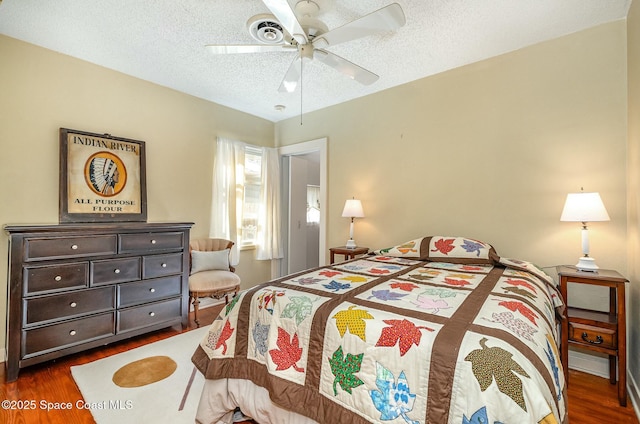 bedroom featuring ceiling fan, a textured ceiling, and dark hardwood / wood-style flooring