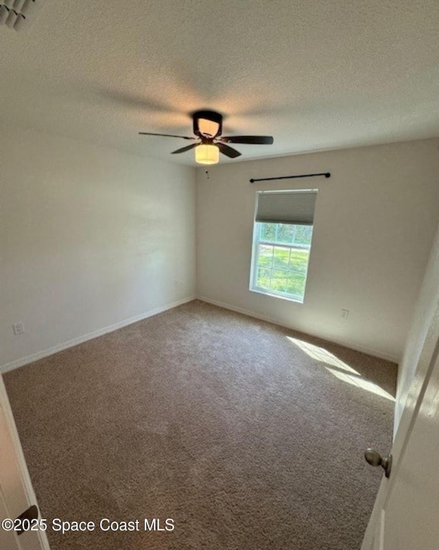 spare room featuring carpet floors, ceiling fan, and a textured ceiling