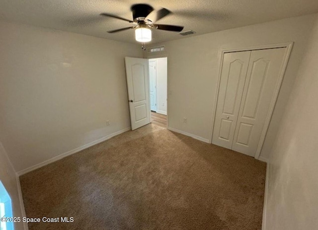 unfurnished bedroom featuring ceiling fan, a closet, carpet, and a textured ceiling