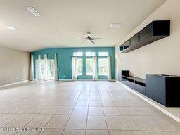 unfurnished living room with ceiling fan and light tile patterned floors