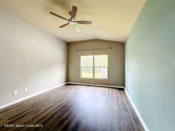 unfurnished room with ceiling fan, dark hardwood / wood-style floors, and vaulted ceiling