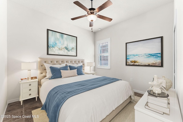 bedroom with ceiling fan and a textured ceiling