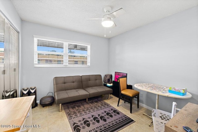 interior space featuring ceiling fan, a textured ceiling, and light tile patterned floors