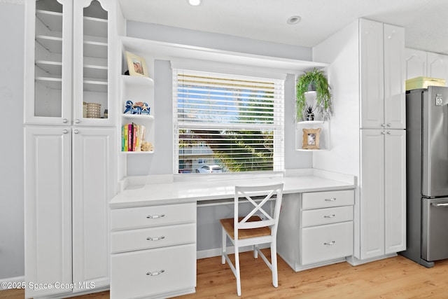 office featuring built in desk and light hardwood / wood-style floors