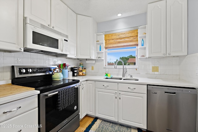 kitchen with white cabinets, appliances with stainless steel finishes, and sink