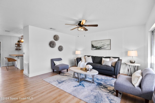 living room with ceiling fan and wood-type flooring