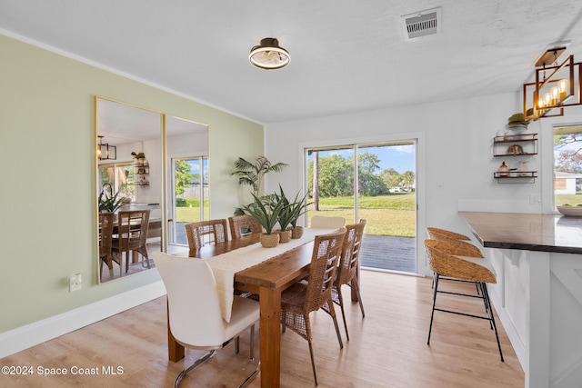 dining space with a notable chandelier and light hardwood / wood-style flooring