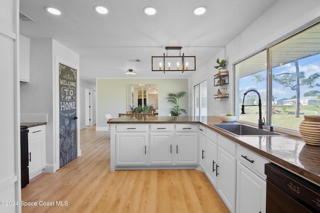 kitchen with white cabinetry, black dishwasher, kitchen peninsula, and sink