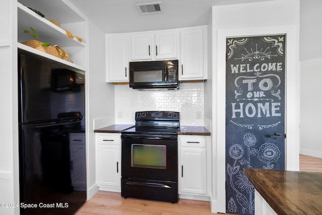 kitchen featuring decorative backsplash, light hardwood / wood-style floors, white cabinetry, and black appliances