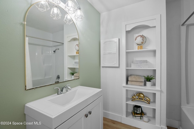 bathroom featuring a shower, hardwood / wood-style flooring, and vanity