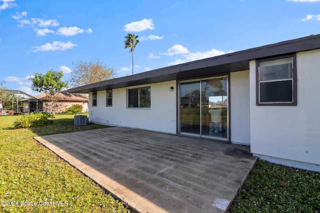 rear view of house with a patio area, central AC unit, and a yard