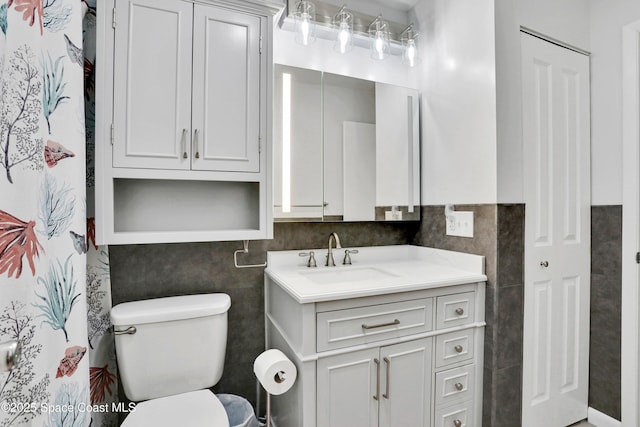 bathroom featuring tile walls, vanity, toilet, and a shower with shower curtain