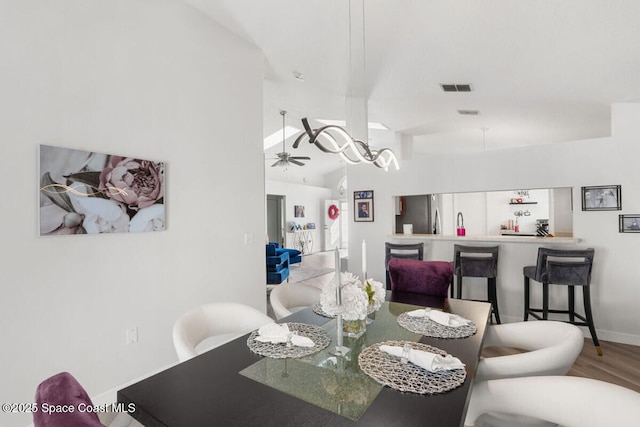 dining area with ceiling fan, lofted ceiling, and hardwood / wood-style floors