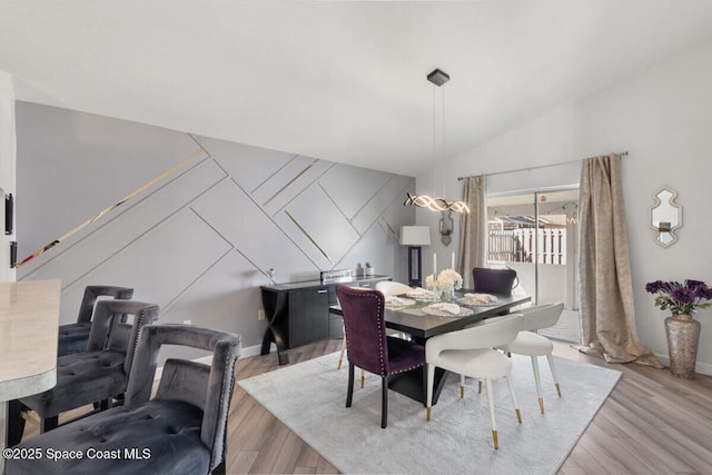 dining space with light hardwood / wood-style floors and vaulted ceiling