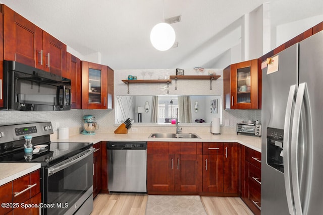 kitchen featuring stainless steel appliances, pendant lighting, tasteful backsplash, and sink