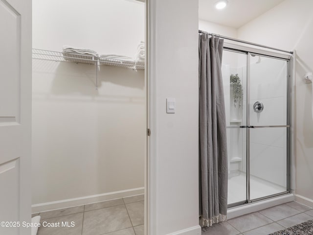 bathroom featuring a shower with shower door and tile patterned flooring