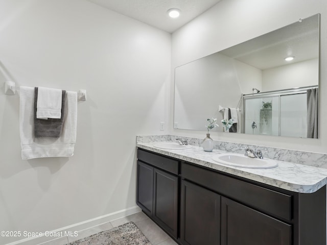 bathroom featuring vanity, a shower with shower door, and tile patterned floors