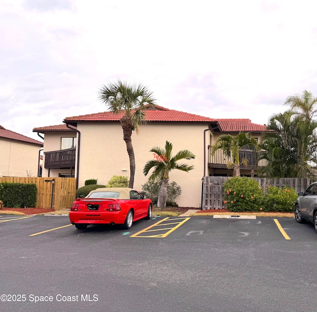 view of property featuring uncovered parking and fence