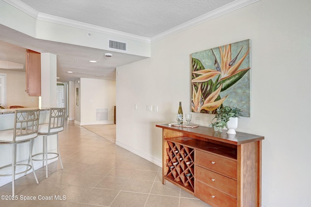 hallway featuring crown molding, light tile patterned floors, and a textured ceiling