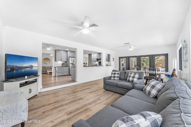 living room with french doors, ceiling fan, and light hardwood / wood-style floors