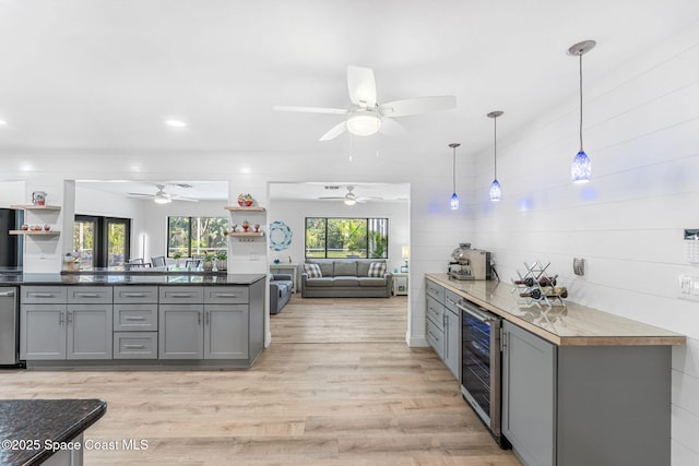 kitchen with wine cooler, decorative light fixtures, light hardwood / wood-style floors, and gray cabinetry