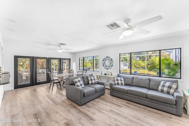 living room with ceiling fan and light hardwood / wood-style floors