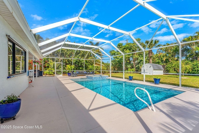 view of swimming pool featuring a yard, a patio area, a storage unit, and glass enclosure