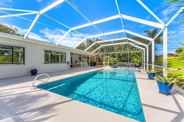 view of pool with a patio and glass enclosure