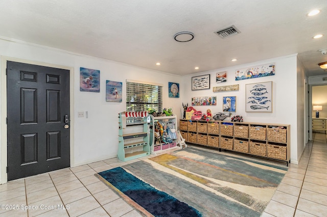 entrance foyer featuring crown molding and light tile patterned flooring