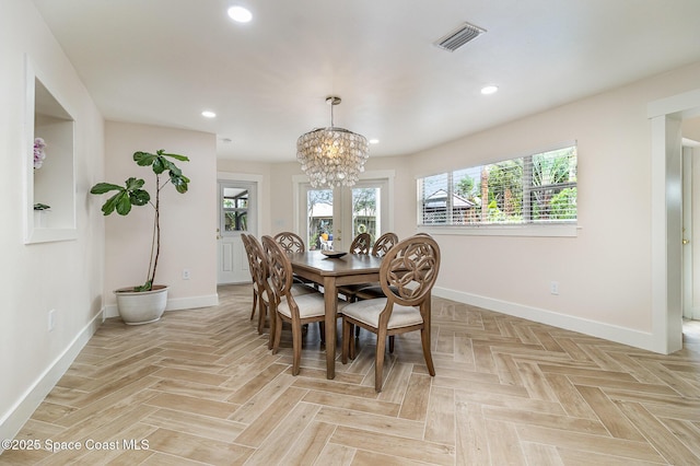 dining room with light parquet floors and a notable chandelier